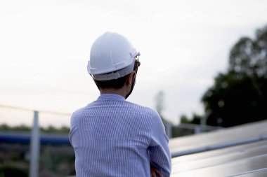 Kadın elektrik mühendisliği ekibi güneş fotovoltaik panellerini kurup inceliyor. Temiz ve çevre dostu alternatif enerji.