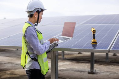 Kadın elektrik mühendisliği ekibi güneş fotovoltaik panellerini kurup inceliyor. Temiz ve çevre dostu alternatif enerji.