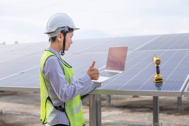 Kadın elektrik mühendisliği ekibi güneş fotovoltaik panellerini kurup inceliyor. Temiz ve çevre dostu alternatif enerji.