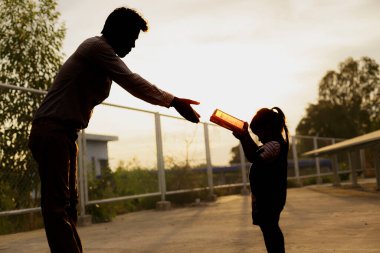 Aile silueti, arka planda gündoğumu gökyüzü ile sabah Tanrı 'ya dua ediyor. İnsanların elleri ibadet için kaldırılır. Tanrı tövbe etmeye yardım ediyor. Roma Katolikliği. Paskalya. Perhiz. Aklını kullan. Dua et. Hıristiyanlık kavramı.