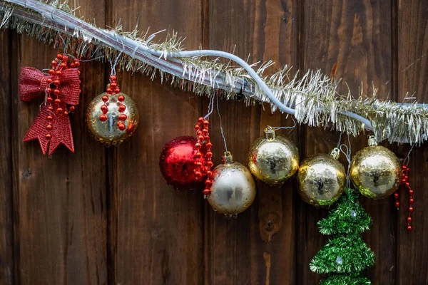 木製の壁の前の光の鎖の上のクリスマスの装飾 — ストック写真