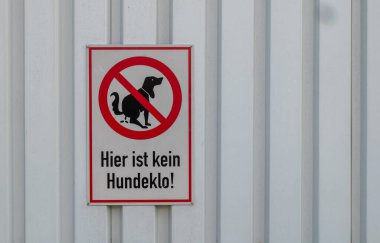 a forbidden sign with the german words here is no dog litter box