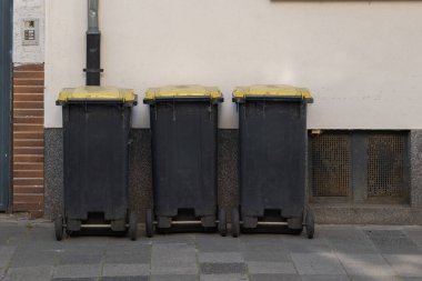 Siyah çöp tenekeleri şehrin kaldırımında