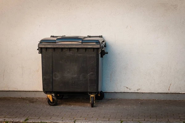 城市人行道上的一个黑色垃圾箱 — 图库照片