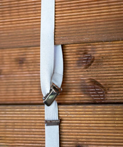 stock image a white suspender on a wooden wall in selective focus