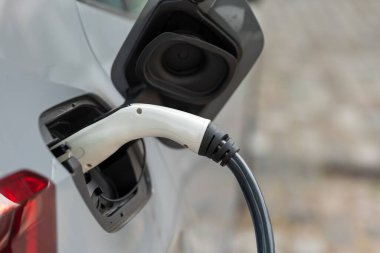 Şarj istasyonunda şarj edilen beyaz bir elektrikli araba.