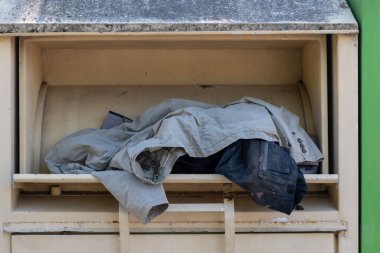 Şehirde eski kıyafet koleksiyonu olan bir konteynır.