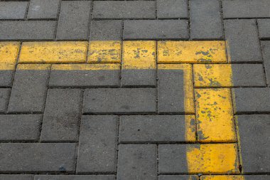 Yukarıdan bakıldığında, kaldırım taşlarında sarı bir iz var.