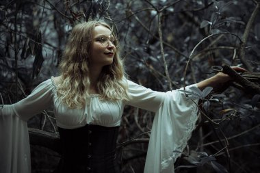 Karanlıkta gotik kıyafetli güzel bir kadın.