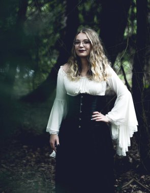 Karanlıkta gotik kıyafetli güzel bir kadın.