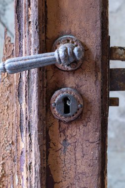 Seçici odak noktasında aşınmış eski bir ahşap kapının kapı kolu.