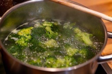 Bir tencerede brokoli ve seçici bir odak noktası olan su.
