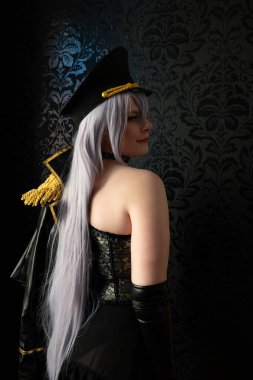 Üniformalı genç bir sadomazoşist arkasını kolluyor.