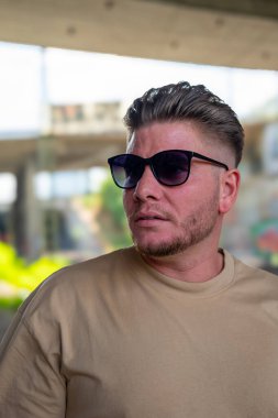 Sakallı ve güneş gözlüklü çekici bir genç adam.