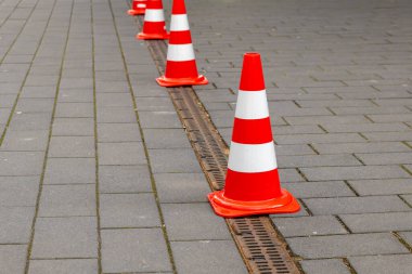 Şehirdeki bir patikada küçük kırmızı ve beyaz yol konileri