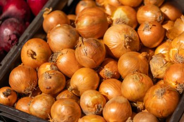 Satış tezgahında soğan dolu bir kutu.