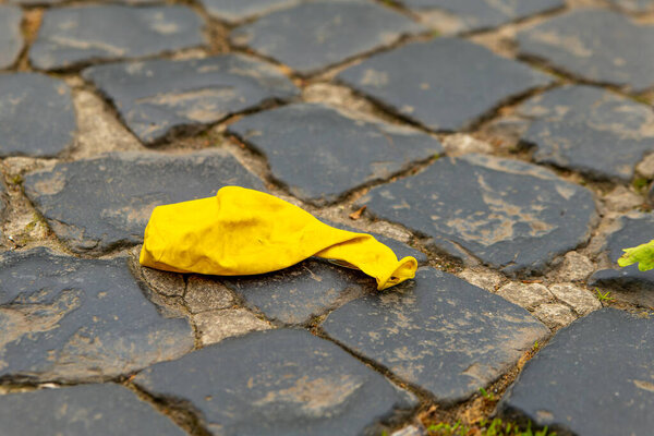 an old destroyed yellow balloon on a footpath