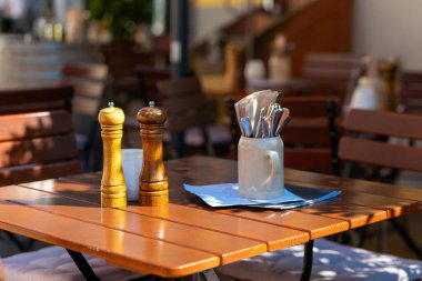 Almanya 'da bir sokak kafesinde tuzluk ve biberlikle dolu bir masa.