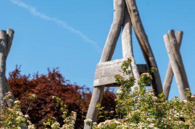 Üç köşeli çatısı olan ahşap bir yapı çiçeklerle çevrilidir.