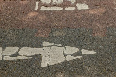 Sağı gösteren beyaz bir okla çatlamış bir kaldırım.