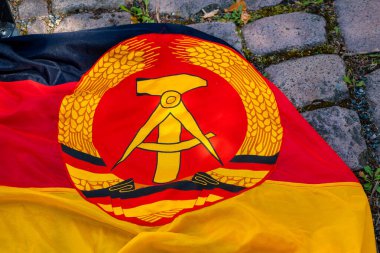 Sokakta çekiç ve pusula olan eski bir GDR bayrağı.