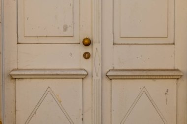 Bir kapı eski ve altın bir düğmesi var.