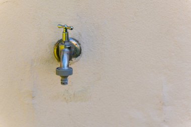 Gümüş musluk duvarda.