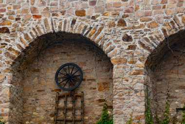 Taş bir duvara bir tekerlek monte edilmiştir.
