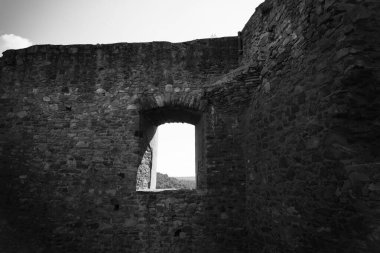 Gökyüzü manzaralı taş bir binanın penceresi.