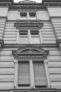 Tek renkli süslü detaylar içeren zarif bir klasik bina cephesi gösteriliyor