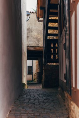 Birinde tahta bir merdiven olan iki bina arasında bir kaldırım taşı geçidi var. Geçit küçük bir avluya açılıyor..