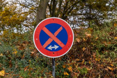 Üzerinde X olan kırmızı ve mavi bir tabela yamaçta.