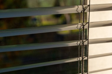 Sabah ışığı, kapalı panjurların kenarlarından usulca geçer. Kapalı bir ortamda sıcak ve huzurlu bir atmosfer yaratır. Huzur ve sükunet önerir..