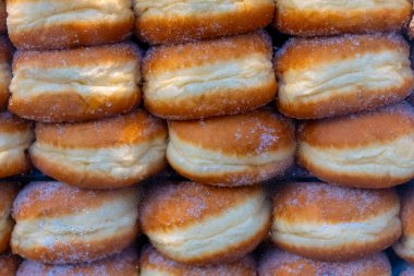 Baştan çıkarıcı bir dizi taze pişmiş çörek bir vitrinde düzgünce düzenlenir. Sıcak, altın ikramları hafif bir şeker tozuyla parıldıyor, karşı konulmaz cazibelerini sergiliyorlar..