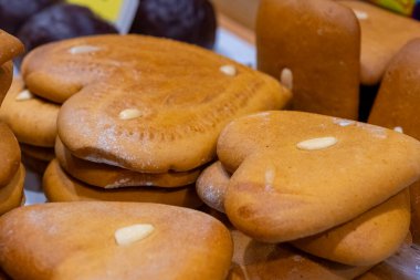 Enfes kalp şeklinde kurabiyeler yerel bir fırında duruyor. Sıcak tonlar ve büyüleyici şekiller, şenlikli bir etkinliğin yoğun öğleden sonrasında ziyaretçileri cezbeder..