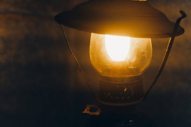 Eski bir fener karanlık bir ortamda yumuşak ve sıcak bir ışık yayar ve gece saatlerinde rahat ve nostaljik bir atmosfer yaratır..