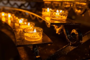 Titrek mumlar süslü bir sunağın üzerine sıcak bir ışık saçıyor ve sakin bir atmosfer yaratıyor. Huzurlu bir akşamda ortam huzur verir..