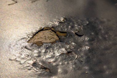 Yıpranmış metal yüzey, soyulmuş boyaları ve ilginç dokuları ortaya çıkararak zaman ve çevrenin etkilerini detaylı bir şekilde gözler önüne seriyor. Doğal ışık özellikleri artırır.