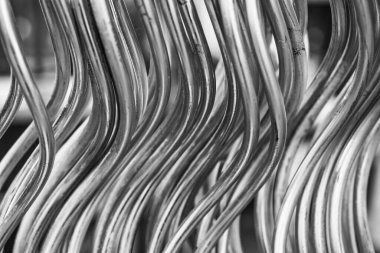 Karmaşık kıvrımlı metal kabloların yakından bakınca çarpıcı ve akışkan bir desen ortaya çıkıyor. Gösterişli tasarım, inşaat veya sanatta kullanılan endüstriyel malzemelerin güzelliğini vurguluyor..