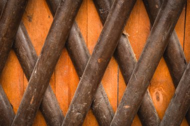 Kırsal ahşap bir kafes, sıcak bir ahşap zemine karşı çaprazlama dizilmiş kalın çapraz çıtçıtlara sahiptir. Doku ve yapı görsel ilgi yaratıyor..