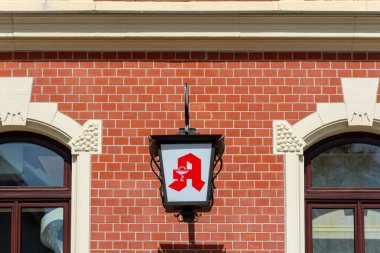 Canlı bir mahallede kırmızı tuğlalı bir binanın önünde güzel tasarlanmış bir fener tabelası asılı. Bu davetkar bar, sıcak atmosferi ve eşsiz kokteylleriyle ziyaretçileri cezbediyor..