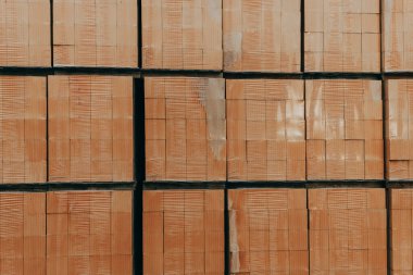 Karton kutular bir depolama tesisinde uzun ve düzenli bir şekilde sevkiyatı bekliyor. Lojistik işçileri önlerindeki yoğun güne hazırlanırken depo enerjiyle yanıp tutuşuyor..