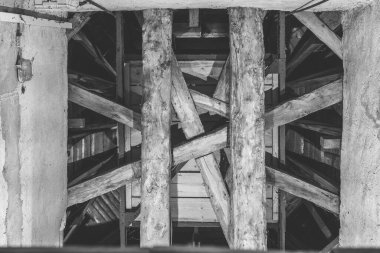 Tarihi bir yapının içinde, tavanda çapraz ahşap kirişler tasarımı var. Bu da zanaat ve yaşı çağrıştırıyor. Alacakaranlık çöktüğünde gölgeler keresteler arasında oynar.