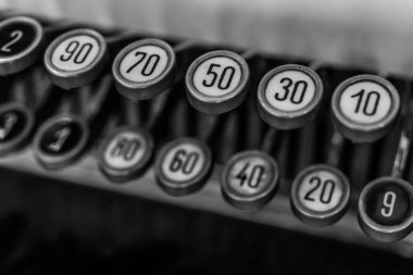 Giyinik daktilo tuşlarının siyah beyaz görüntüsü, eşsiz numaralar ve dokular sergiliyor. Bu klasik yazma ve basitlik için nostalji hissi uyandırıyor..