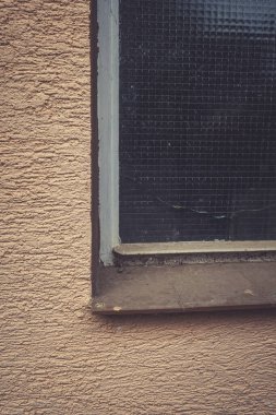 Yumuşak ışık, kaba dokular ve ince renklerle süslenmiş eski bir pencereden süzülür. Öğleden sonra etrafındaki mimarinin sakin atmosferini yansıtır..