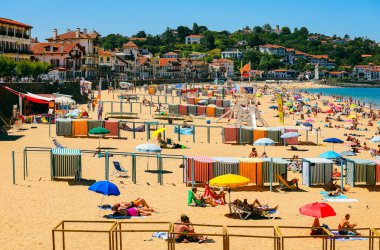 Saint Jean de luz, Fransa - 7 Nisan 2019 Dinlenen insanlarla dolu güneşli plaj manzarası ve Fransa 'nın güneyinde yüzme
