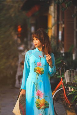 Ao Dai elbiseli kadın Hoi an, Vietnam 'da sokakta yürüyor.