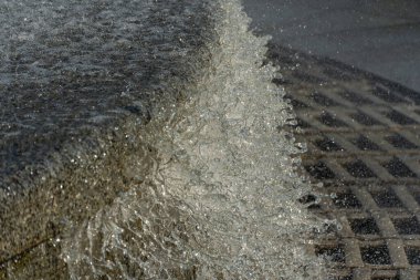 Movement transparent splash. Sparkling gush water of liquid drops detail. Fountain flows like of stream in the city in sunny weather. Refreshing cool water on hot day. Sprays in summertime close up.
