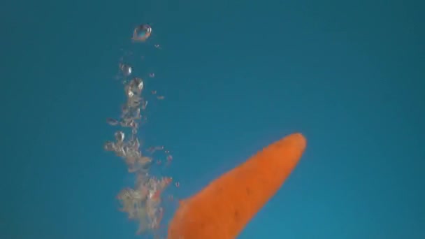 Медленное Движение Свежей Сочной Оранжевой Морковки Падает Воду Брызгами Пузырьками — стоковое видео