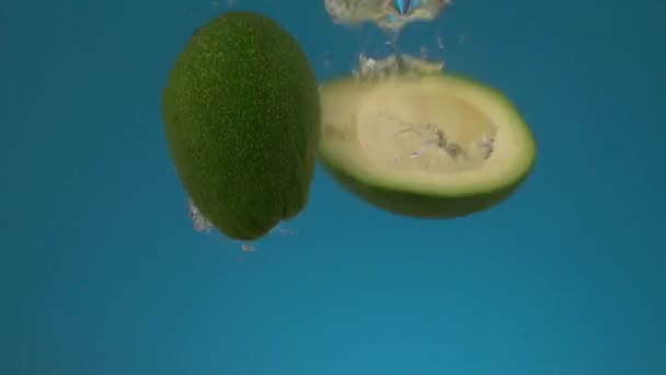 Slow Motion Fresh Juicy Green Sliced Avocado Falls Water Splashes — Stock Video